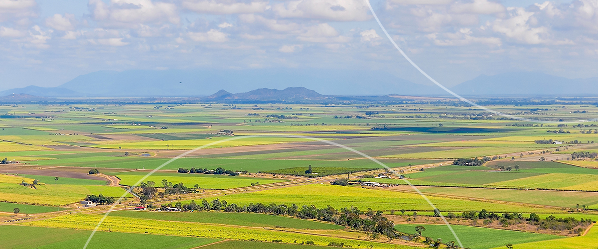 Aerial view of a farmland valley with fields and low hills